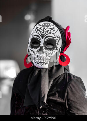 Couleur sélective, noir et rouge, portrait de femme portant un masque de crâne en sucre pour dia de los muertos / le jour des morts célébré au Mexique Banque D'Images