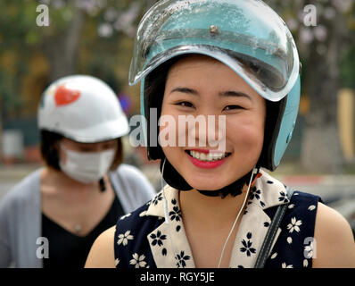 Jeunes vietnamiens scooter femme porte un casque de moto bleu. Banque D'Images