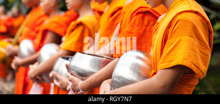 Les jeunes moines Bouddhistes sur leur procession du matin pour des offrandes de nourriture près d'un monastère Banque D'Images