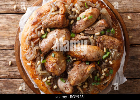 Le plat de poulet aux Palestiniens le sumac, noix de pin et les oignons sur un pain plat libre sur la table supérieure horizontale. Vue de dessus Banque D'Images