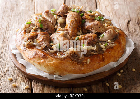 Repas de poulet du Moyen-Orient avec le sumac, noix de pin et les oignons sur un pain plat libre sur la table horizontale. Banque D'Images