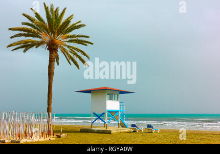 Plage de sable avec palmier et tour de garde de la vie à Larnaca, Chypre Banque D'Images