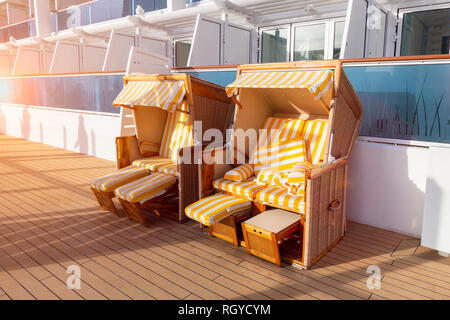 Chaises de plage en osier couvert sur le pont d'un navire de croisière. Banque D'Images