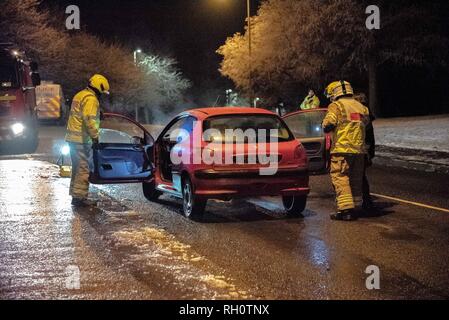 Un membre du Service des incendies est vu parler avec le propriétaire des véhicules avant que le véhicule soit poussé hors de la route. Une voiture a pris feu ce soir sur la B9096 en Tullibody. La police et d'incendie et de sauvetage étaient sur scène. Il n'y a pas de blessés. Fire & Rescue mis le feu et l'éteindre. Banque D'Images