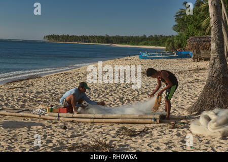 Les pêcheurs réparant leurs filets, Saud Beach, Pagudpud, Luzon, Philippines Banque D'Images