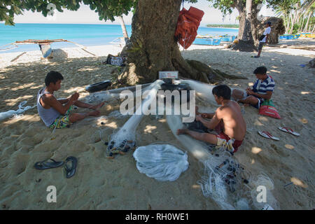 Les pêcheurs réparant leurs filets, Saud Beach, Pagudpud, Luzon, Philippines Banque D'Images