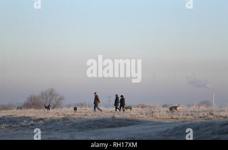 Les promeneurs de chiens font leur chemin à travers le sol glacial de Basingstoke, Hampshire en commun après le Royaume-Uni avait sa nuit la plus froide de l'hiver jusqu'à présent que la vague de froid continue de causer des conditions glacées à travers le pays. Banque D'Images