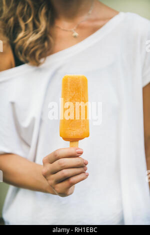 Agrumes Mango ice cream glace dans woman's hand Banque D'Images