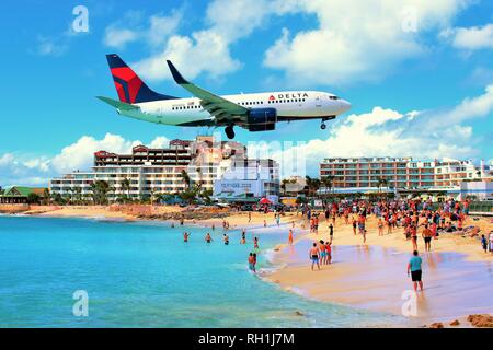 Plage de Maho, Sint Maarten, Antilles - 27 Février 2018 : un avion de Delta Air Lines vole bas au-dessus de la célèbre plage de Maho avant d'atterrir à l'aéroport SXM. Banque D'Images