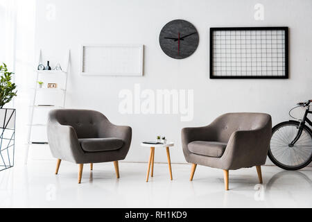 Intérieur moderne de white hall d'attente avec table et fauteuils gris Banque D'Images