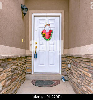 Entrée étroite d'une maison avec porte avant blanc Banque D'Images