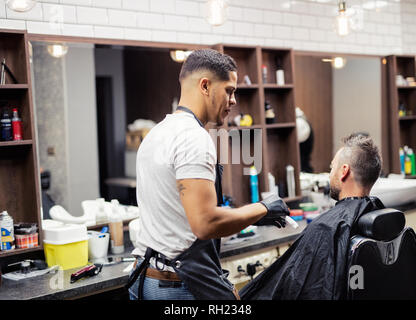 Vue arrière de l'homme tourné en visite client et coiffeurs coiffeur dans un salon de coiffure. Banque D'Images