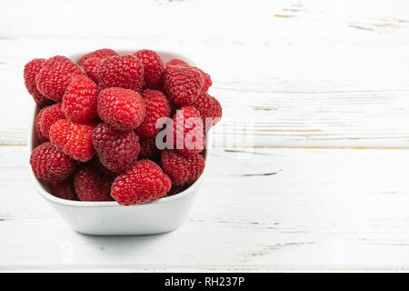 Avec la plaque de bois rustique framboise sur fond blanc.Copy space Banque D'Images