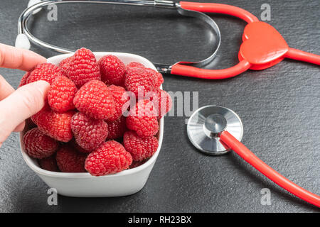 Avec la plaque sur fond noir en noir framboise.stéthoscope.alimentation saine notion Banque D'Images