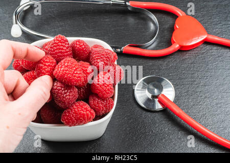 Avec la plaque sur fond noir en noir framboise.stéthoscope.alimentation saine notion Banque D'Images