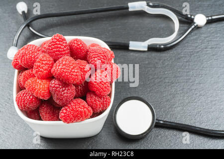 Avec la plaque sur fond noir en noir framboise.stéthoscope.alimentation saine notion Banque D'Images