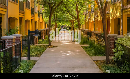 Chemin au milieu de maisons et arbres Banque D'Images