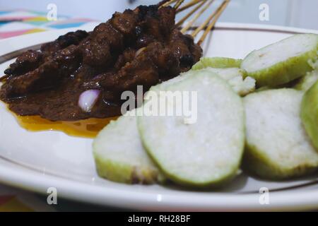 L'un de l'Indonésie, de l'alimentation traditionnelle poulet satay avec gâteau de riz (Lontong) Banque D'Images