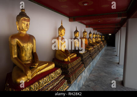 Jeune femme ressemble à la rangée de statues de Bouddha d'Or de Wat Pho Thaïlande Bangkok Palace Banque D'Images