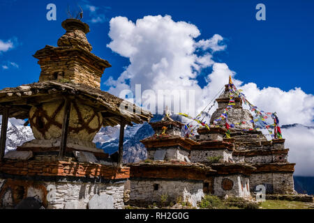 Un groupe de chorten, stupas, est situé à l'entrée du village, la neige a couvert de montagnes de la distance Banque D'Images