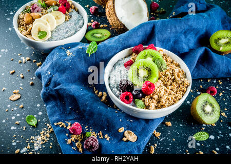 Granola fait maison avec des graines de chia pudding yaourt, fruits frais et fruits rouges, bleu foncé sur fond de béton copy space Banque D'Images