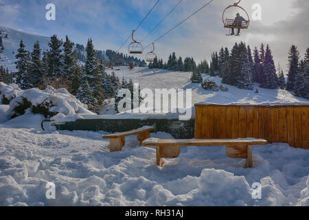 Belle vue de la montagne avec des bancs en bois, des chaises modernes et forêt à Karakol, le Kirghizistan. Banque D'Images