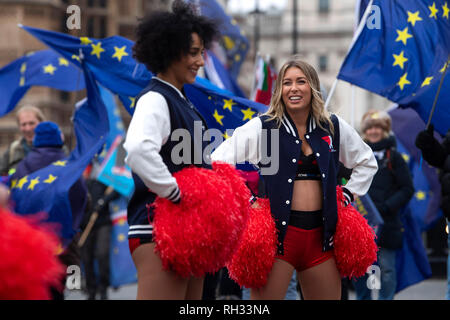 Red Zone.bet cheerleaders jouer devant des manifestants anti-Brexit devant les Maisons du Parlement, Londres, avant le Superbowl entre les Los Angeles Rams et les New England Patriots le dimanche. Banque D'Images