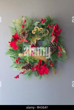 Une couronne de Noël suspendu à une porte avant pendant les vacances d'hiver. Banque D'Images