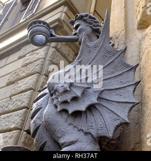 Moitié homme moitié aile bougeoir dragon et l'hitching post sur le mur de pierre d'une rue de Florence Italie Banque D'Images