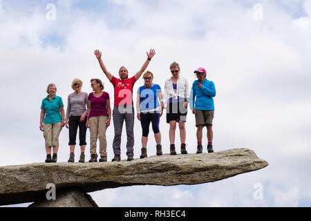 Un groupe de randonneurs heureux certaines personnes se tenant sur le rocher cantilever sur la montagne de Glyder Fach dans le parc national de Snowdonia. Ogwen Conwy Pays De Galles Grande-Bretagne Banque D'Images