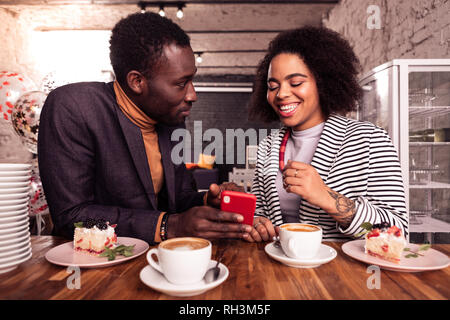 Joyeux positif homme tenant un smartphone dans la main Banque D'Images