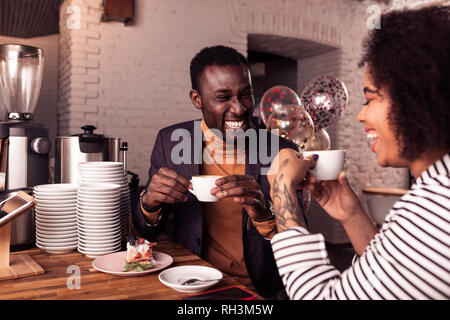 Nice positive heureux couple having coffee together Banque D'Images