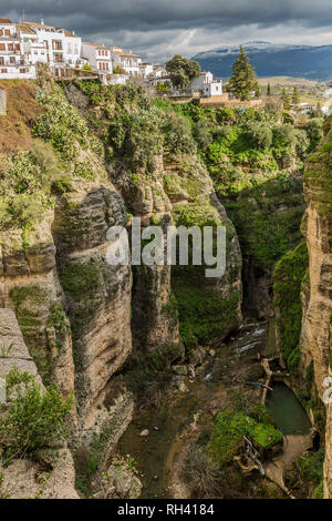 Canyon ou Tajo de Ronda avec les bâtiments blancs dans la partie supérieure de la rivière Guadalevín avec, journée ensoleillée avec des nuages dans la province de Malaga Espagne Banque D'Images