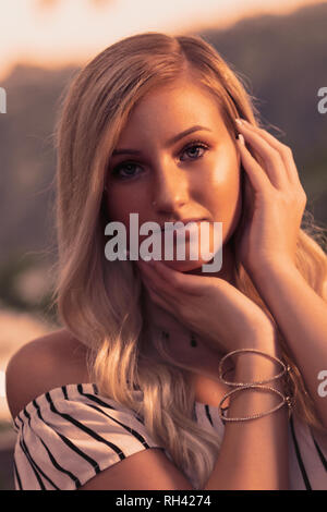 Une belle chevelure blonde woman posing senior high school pour les photos. Une adolescente portrait outdoors at park en été. Banque D'Images