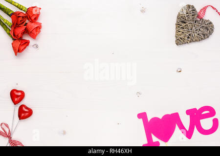 Table top voir l'image de la décoration Valentines Day background concept.L'Arrangement de roses rouges artificielles et coeurs avec objets de décoration sur fond blanc Banque D'Images