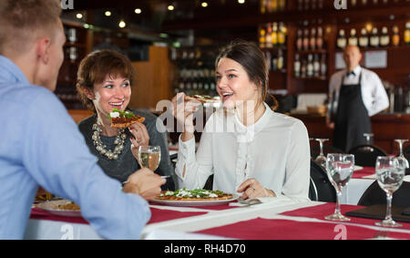 Les femmes d'affaires avec l'homme partenaire ayant le dîner et boire du vin au restaurant Banque D'Images