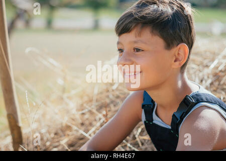 Smiling boy sitting in hay Banque D'Images