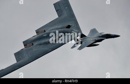 Northrop Grumman B-2 Spirit stealth bomber escorté par des chasseurs à réaction F-15 Eagle au Royal International Air Tattoo 2017 Banque D'Images