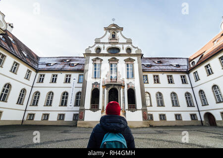 Füssen, ALLEMAGNE - Décembre 2018 : woman in red hat debout à l'arrière-cour du monastère bénédictin de Saint Mang Banque D'Images