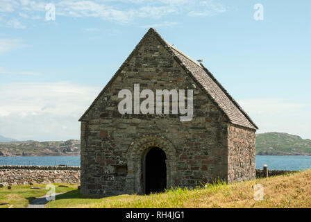 L'ancien 12ème siècle Chapelle St Rore avec le son d'Iona dans l'arrière-plan sous le soleil d'été. Banque D'Images