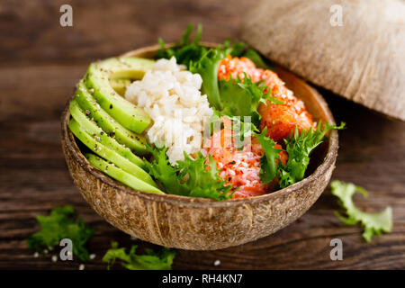 Hawaiian poke bol de noix de coco avec du saumon grillé du poisson, du riz et d'avocat. L'alimentation saine Banque D'Images