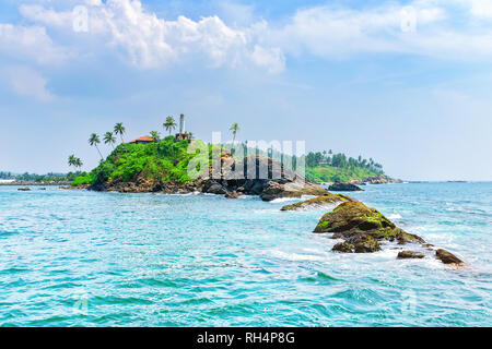 L'été à la jungle de l'île de l'océan. Panorama de l'île tropicale avec palmiers, entouré par une mer turquoise. Paysage onirique. Le phare sur les rochers. Banque D'Images