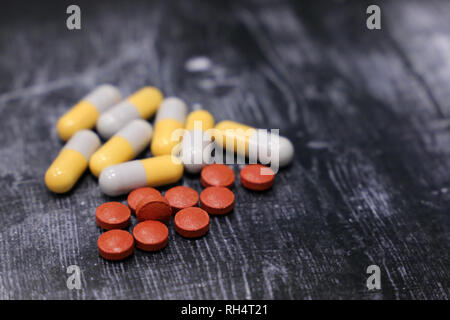 Comprimés et gélules sur table en bois foncé, selective focus. Concept de la polypharmacie, médicaments, les vitamines, les soins de santé Banque D'Images