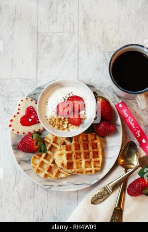 Valentines Day breakfast gaufres en forme de coeur bol de granola yogourt fraises fraîches, overhead view Banque D'Images