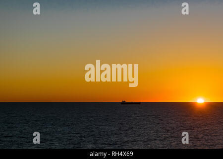 Scenic lever du soleil sur l'océan Atlantique près de la côte est du Canada. Silhouette d'un cargo de la voile. Banque D'Images