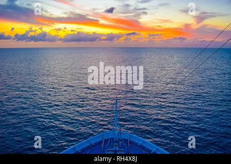 La voile vers le soleil couchant sur la mer des Caraïbes. Ciel coloré. Banque D'Images