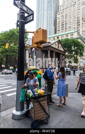 La ville de New York, USA - Le 26 juillet 2018 : Vendeur dans son panier d'aliments avec des personnes dans la région de Manhattan à New York City, USA Banque D'Images