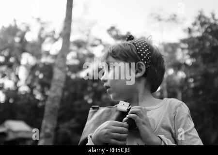 Un portrait d'une jeune fille à côté d'arbres en arrière-plan flou, Finch Hatton, Queensland 4756, Australie Banque D'Images