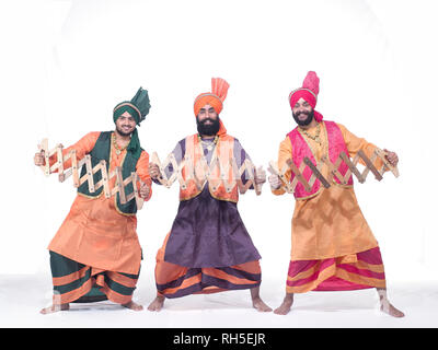 PORTRAIT D'UN GROUPE DE TROIS Danseurs de BHANGRA DANSE AVEC SERPENT EN BOIS APPELÉE SAAP Banque D'Images