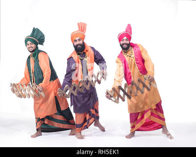 PORTRAIT D'UN GROUPE DE TROIS Danseurs de BHANGRA DANSE AVEC SERPENT EN BOIS APPELÉE SAAP Banque D'Images